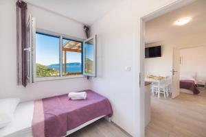 a bedroom with a bed and a window and a table at Camping Homes Grot in Gradac