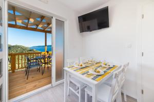 una sala da pranzo bianca con tavolo e balcone di Camping Homes Grot a Gradac (Grado)