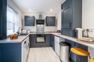 a kitchen with blue cabinets and white counters at South View - 3 bed modern Chester house - Close to city centre in Chester