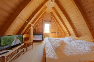 a bedroom with a large bed in a wooden house at Strandvogt 2 TR8 in Dorum Neufeld