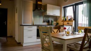 une cuisine avec une table en bois et des chaises ainsi qu'une salle à manger dans l'établissement Die Pfalzherberge, à Waldfischbach-Burgalben