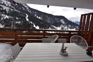 a table on a deck with a view of a mountain at VAUJANYLOCATIONS - Saphir 04 in Vaujany