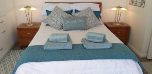 a bed with two pillows and towels on it at Wave Dancer in Gansbaai