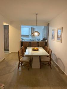 een eetkamer met een witte tafel en stoelen bij Apartamento frente Mar Santos in Santos