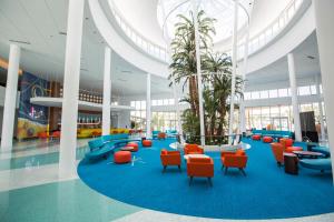 a lobby with blue and orange chairs and palm trees at Universal's Cabana Bay Beach Resort in Orlando