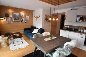 a living room with a table and a couch at VAUJANYLOCATIONS - Saphir 04 in Vaujany