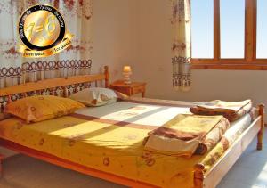 a bedroom with a wooden bed and a window at Pension Dicev in Obzor