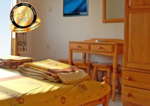 a bedroom with a bed and a desk and a clock at Pension Dicev in Obzor