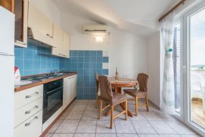 a kitchen with a table and chairs in a room at Apartments Friganović in Vodice