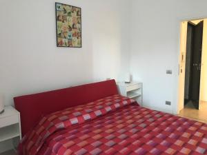 sypialnia z czerwonym łóżkiem i kocem szachowym w obiekcie Venice Homes & Holidays w Wenecji