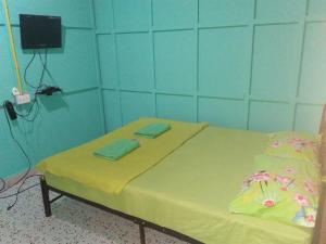 a hospital room with a bed and a television at บ้านพักกลางนา in Amphoe Sawang Daen Din