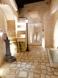 a hallway with a stone floor and a staircase with a light at 5 Elementi Sassi Matera in Matera