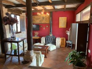 a living room with red walls and a stove at El Pósito in Hita