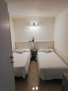 two beds in a small room with white walls at Appartamento Casa Pace Tremosine in Tremosine Sul Garda