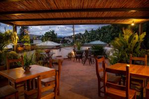 a patio with wooden tables and chairs and plants at La Cochinilla Hotel Boutique in Oaxaca City