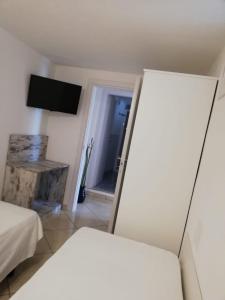 a room with two beds and a television and a door at Appartamento Casa Pace Tremosine in Tremosine Sul Garda