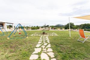 a rock path in a yard with a playground at Agriturismo "Lu Puzzu" in Torre Lapillo