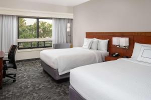a hotel room with two beds and a desk at Sonesta Select Miami Lakes in Miami Lakes
