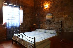 1 dormitorio con 1 cama en una pared de piedra en Agriturismo Il Pozzo, en Casal Velino