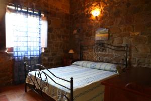 a bedroom with a bed in a stone wall at Agriturismo Il Pozzo in Casal Velino