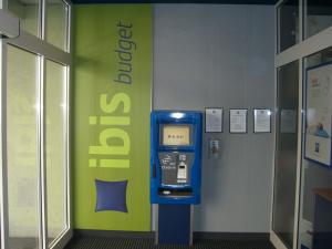 a atm machine in a room with a green wall at Ibis Budget Graz City in Graz