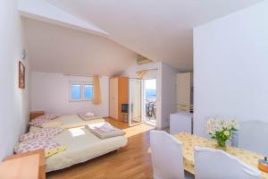 Un dormitorio con dos camas y una mesa y sillas. en Apartments Cihorich, en Dugi Rat 73 fotos más