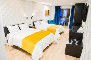 a hotel room with two beds with yellow and white sheets at Ramë Hotel Boutique in Guadalajara