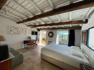 a bedroom with a bed and a desk and a television at Quinta do Barrieiro - Art Selection by Maria Leal da Costa in Marvão