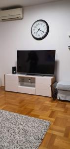 sala de estar con TV y reloj en la pared en Luna Apartments, apartments with style, en Zagreb