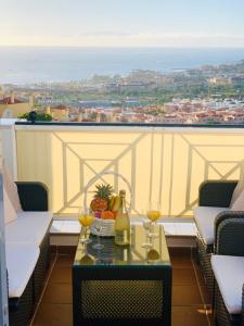 una mesa con una botella de vino y copas en el balcón en Duplex Penthouse Panoramic Del Atlantico en Adeje
