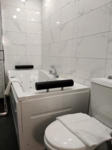 een witte badkamer met een toilet en een wastafel bij Hotel Perfect in Varna