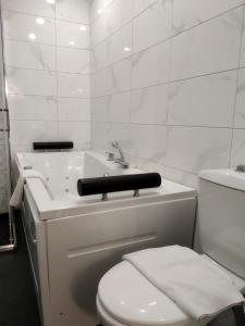 La salle de bains blanche est pourvue de toilettes et d'un lavabo. dans l'établissement Hotel Perfect, à Varna