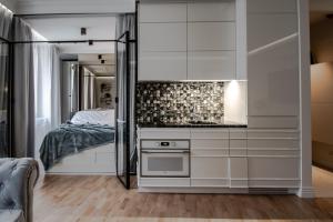 a bedroom with a bed and a white cabinet at Apartament Gold 300 m do Plaży - Praia Apartments Sopot in Sopot