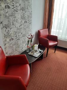 una sala de espera con 2 sillas y una mesa en Pensiunea Caramell, en Cluj-Napoca