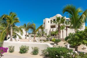 a resort with palm trees and a building at Terrasol Elite Premium Vacation Rentals in Cabo San Lucas
