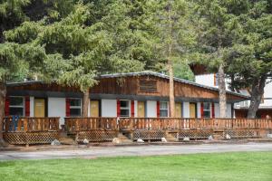 a building with benches in front of trees at Alpine Lodge Red River in Red River
