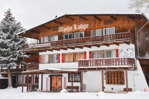 a ski lodge with snow in front of it at Alpine Lodge Red River in Red River