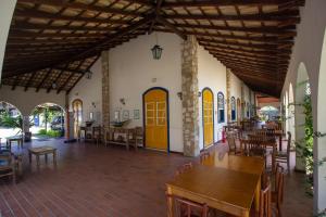 un restaurante con mesas, sillas y puertas amarillas en Villas De Paraty, en Paraty