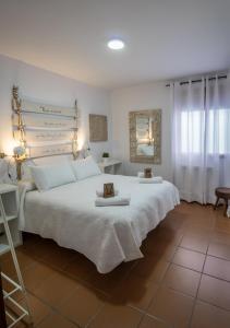 1 dormitorio con 1 cama blanca grande y 2 toallas en Alojamientos Siente Cazorla en Cazorla