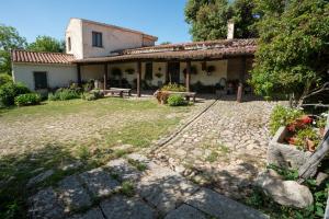 - Vistas externas a una casa con jardín en Agriturismo Testone, en Benetutti