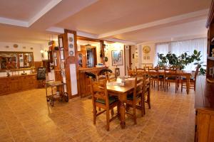 a dining room with a table and wooden chairs at Pensiunea Nordica in Statjunea Borsa