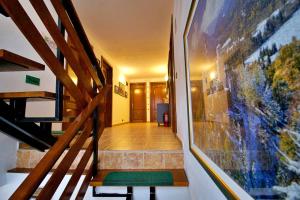 korytarzem ze schodami i zielonym dywanem w obiekcie Pensiunea Nordica w mieście Statjunea Borsa