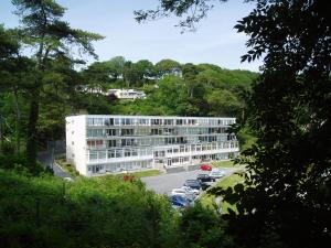 a white building with cars parked in a parking lot at 2A Redcliffe Apartment in Bishopston