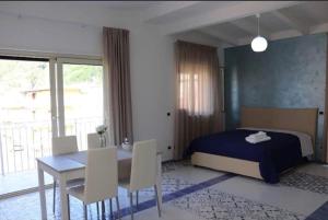 a bedroom with a bed and a table and chairs at Samuel Fish in Bagnara Calabra