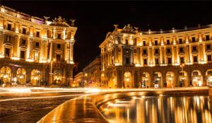 una calle de la ciudad con dos edificios por la noche en Alius and Freerome Hotel en Roma