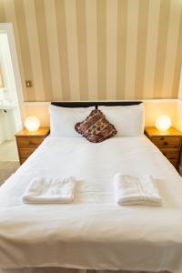 a white bed with two towels on top of it at Elder York Guest House in Edinburgh
