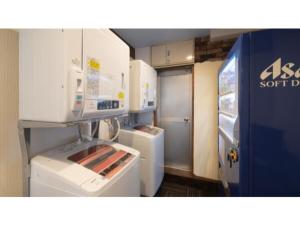 a kitchen with white appliances and a refrigerator at Self inn Tokushima kuramoto ekimae - Vacation STAY 19491v in Tokushima