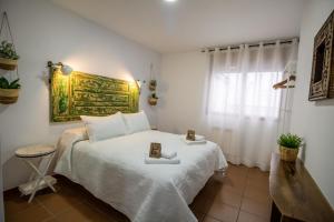 a bedroom with a white bed and a window at Siente Cazorla Alojamientos in Cazorla