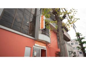 an orange building with a tree in front of it at Self inn Tokushima kuramoto ekimae - Vacation STAY 19485v in Tokushima