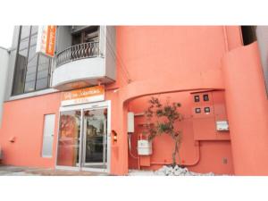an orange building with a tree in front of it at Self inn Tokushima kuramoto ekimae - Vacation STAY 19485v in Tokushima +5 photos